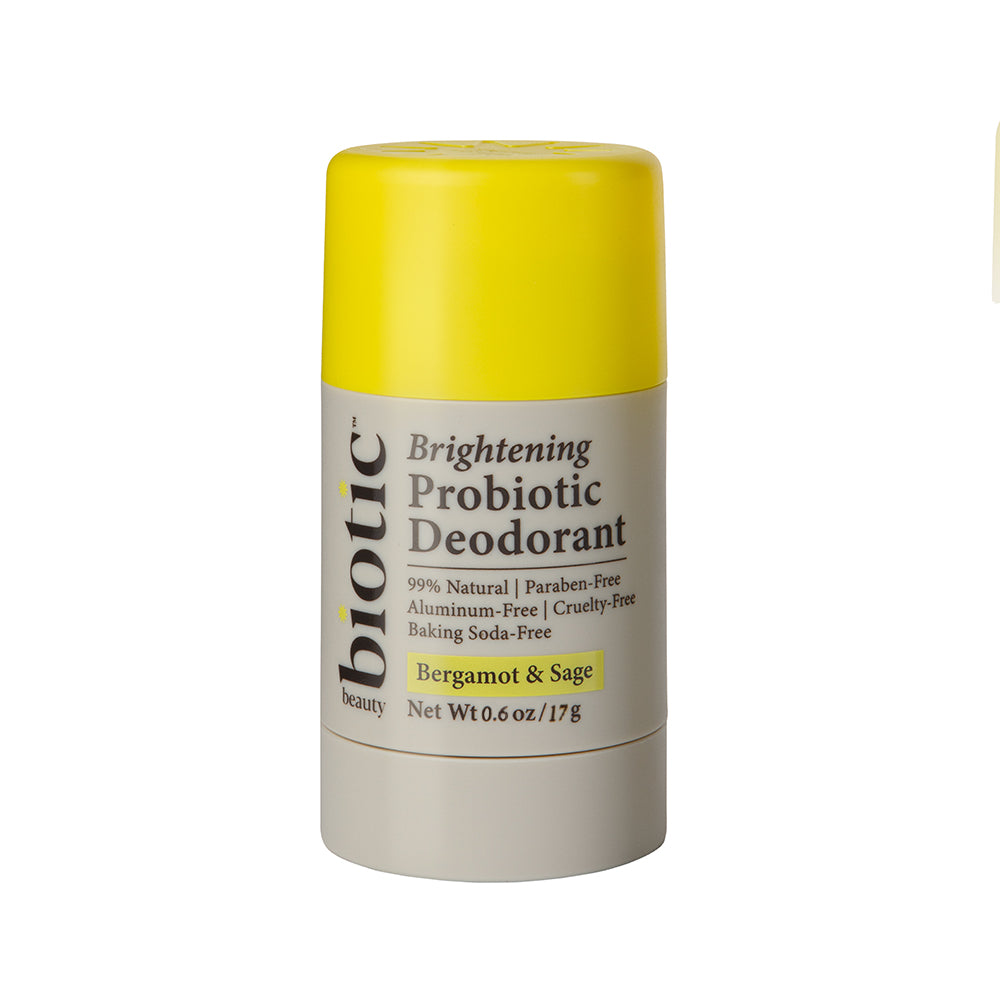 A stick deodorant with a yellow cap labeled 'Brightening Probiotic Deodorant' by Biotic Beauty with additional text indicating the scent as Bergamot & Sage and stating that it is 99% natural.