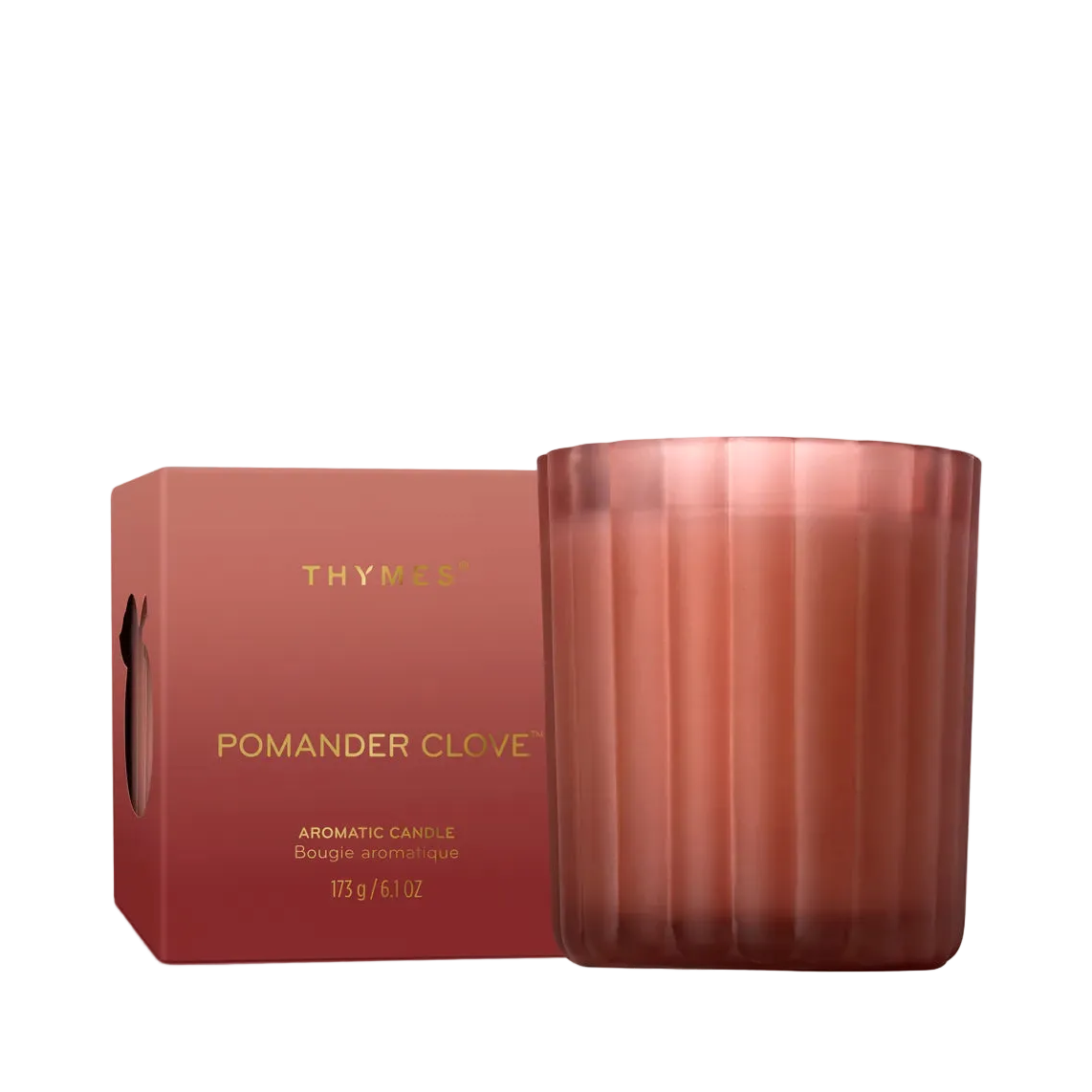 A Thymus Pomander Clove scented candle in a ribbed translucent rose-gold glass jar next to its matching rose-red cardboard box with gold lettering, set against a plain white background.