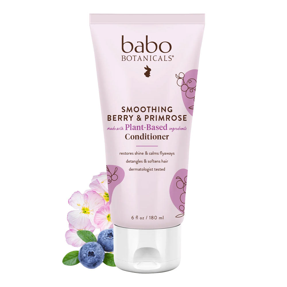 Tube of Babo Botanicals Smoothing Berry & Primrose Plant-Based Conditioner next to blueberries and flowers
