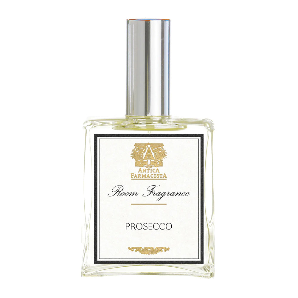 A clear glass bottle with a metallic cap labeled 'Antica Farmacista Room Fragrance Prosecco'.
