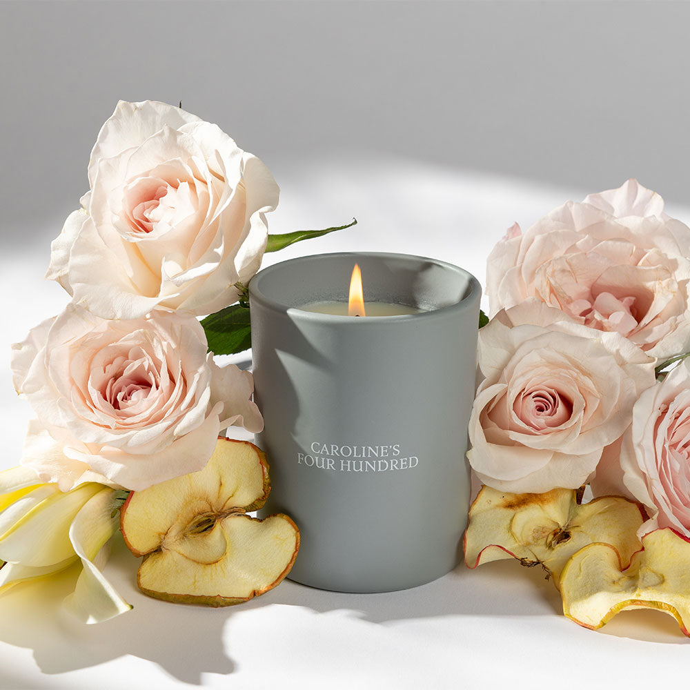 Gray candle amongst roses and dried apple slices