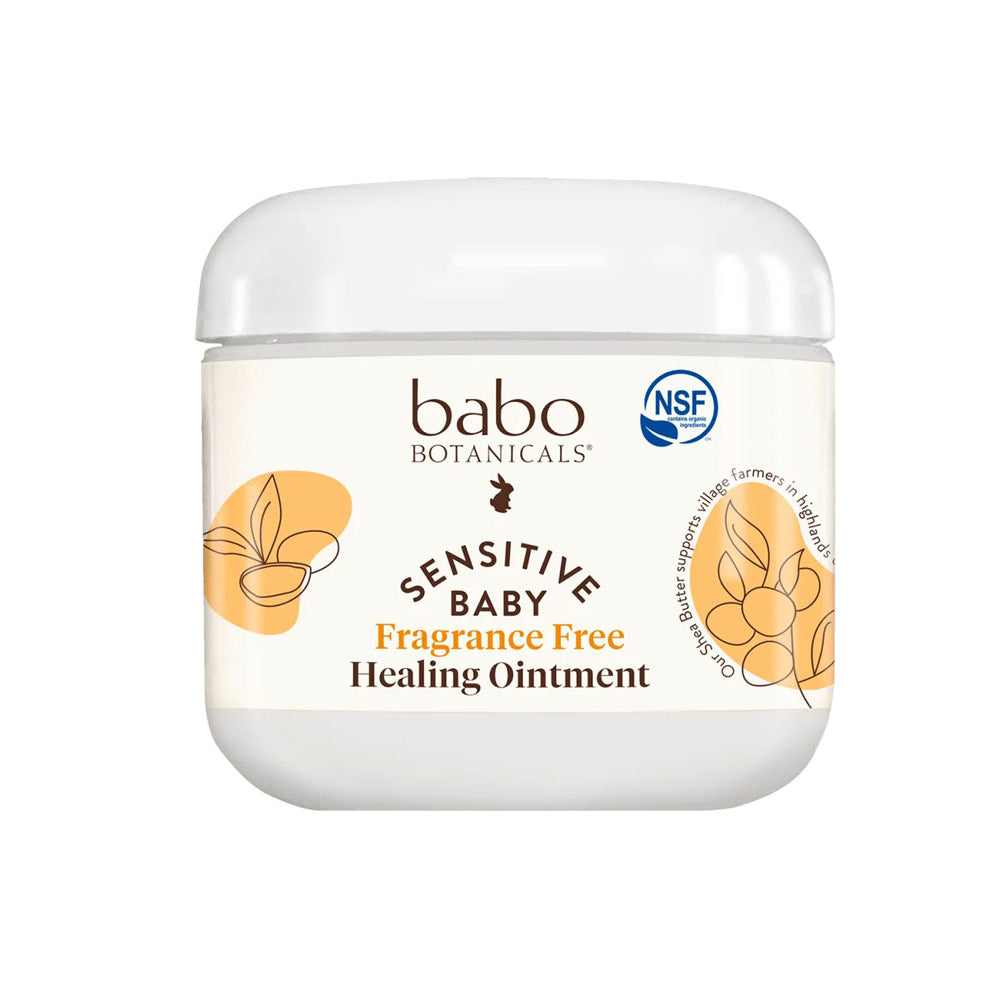 A white jar of Babo Botanicals Sensitive Baby Fragrance Free Healing Ointment with botanical design accents on the label.