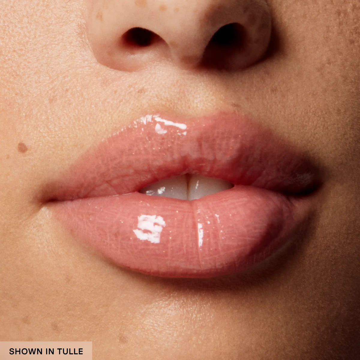 Close-up of glossy pink lips with a neutral background