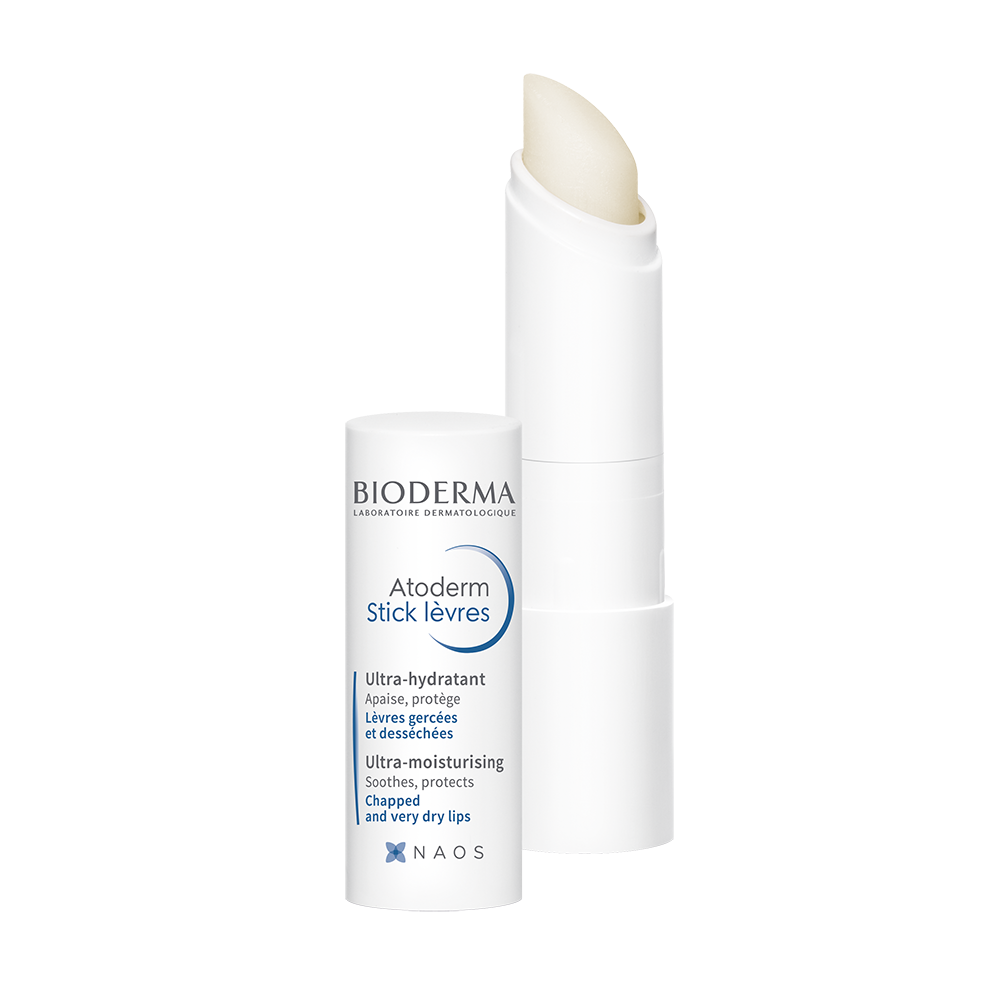 A white stick of Bioderma Atoderm Lip Stick next to its cap with blue and green text detailing the product's properties.