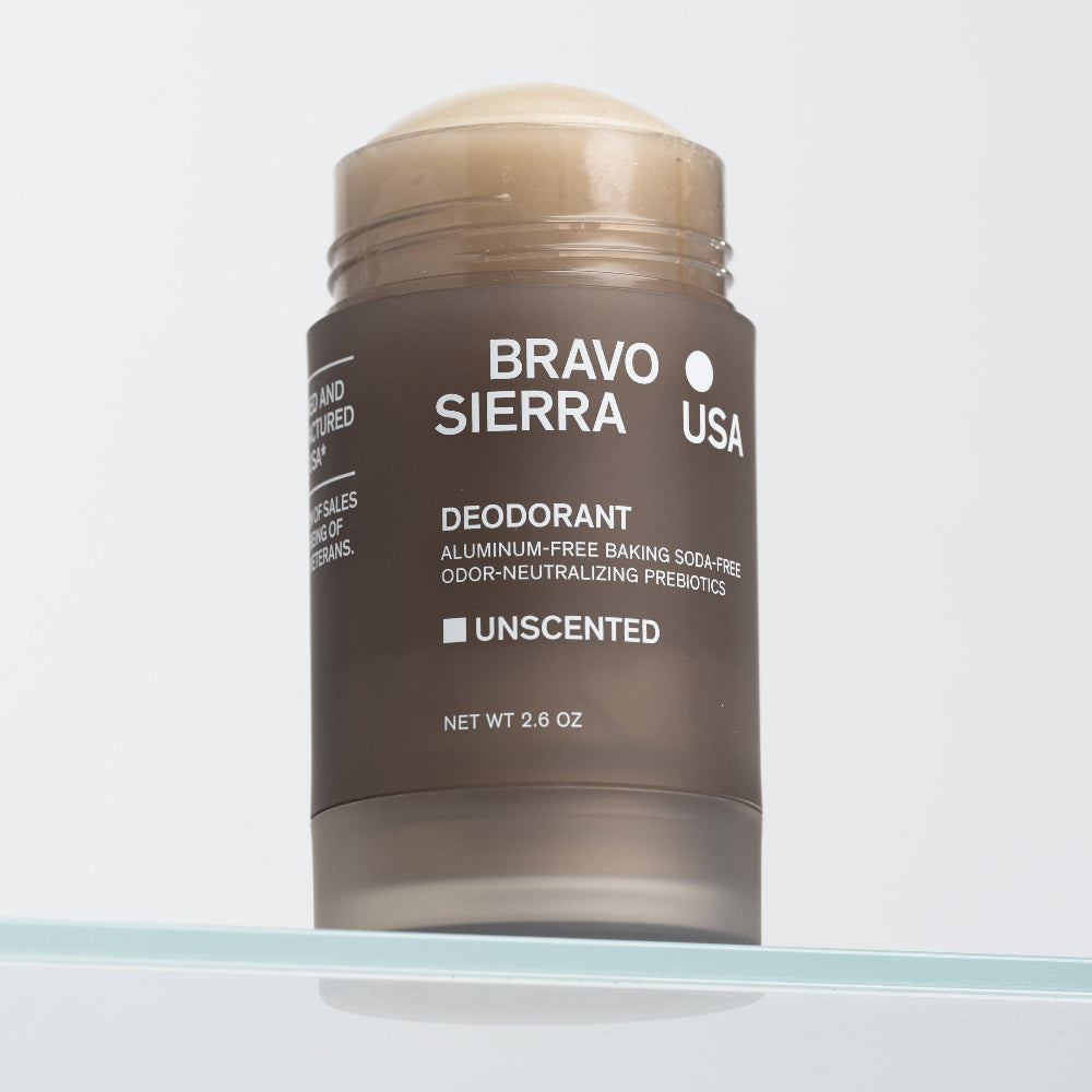 Close-up of an open tube of Bravo Sierra's Unscented Deodorant on a glass shelf. 